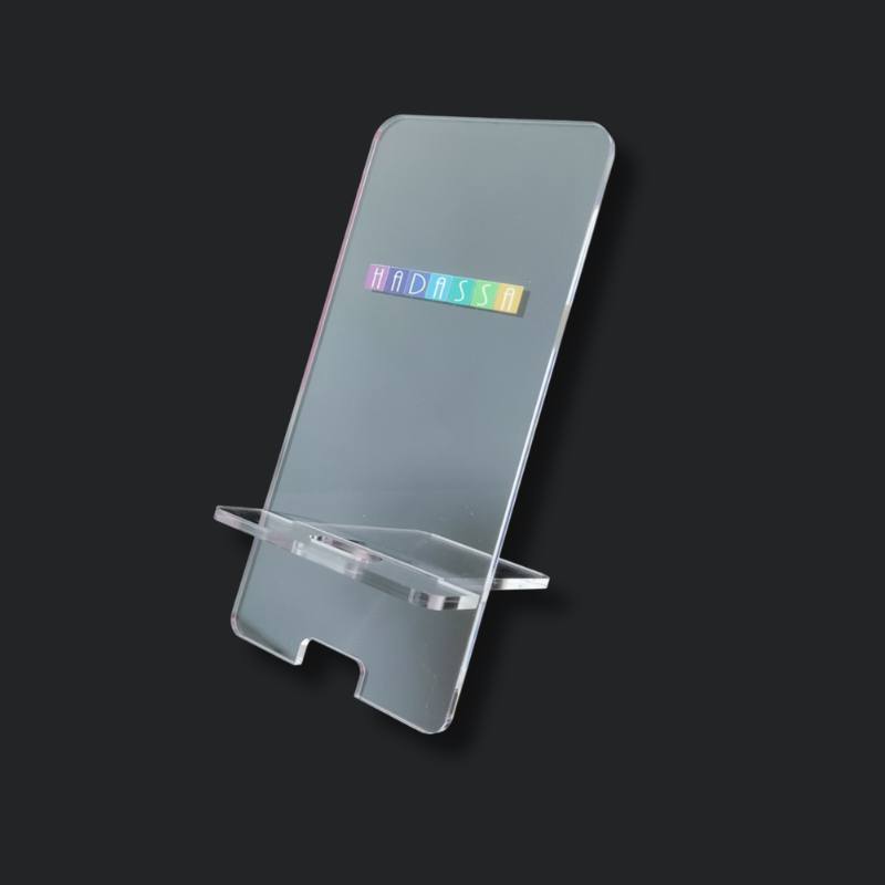 Porta Celular Acrílico Transparente con logo en la parte superior, fondo oscuro.